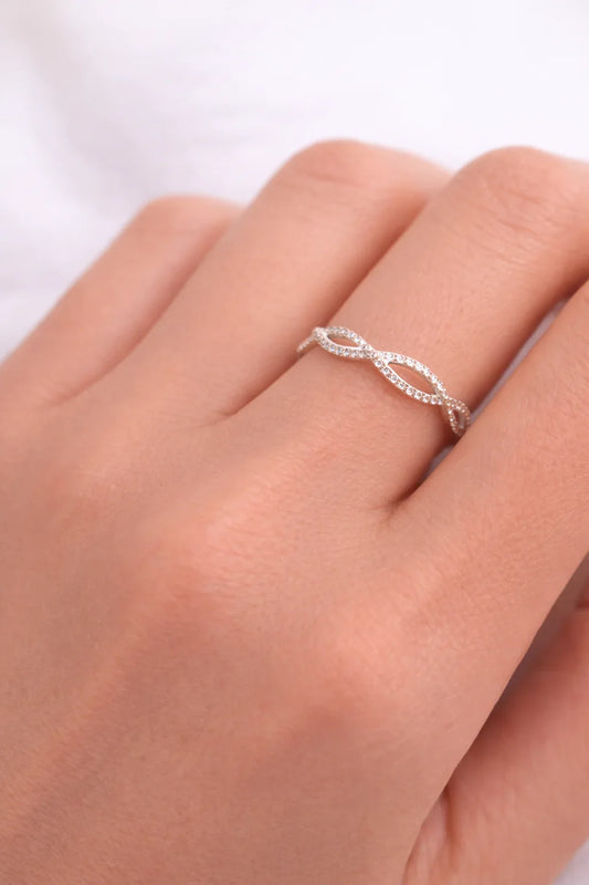 Bague torsadée en argent ornée de petits diamants portée sur un doigt