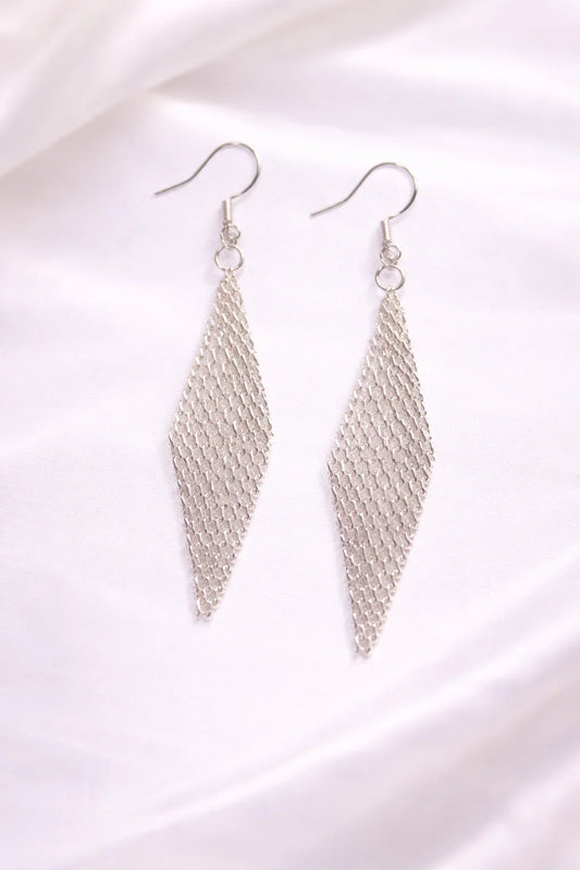 Boucles d'oreilles longues en chaîne argentée forme losange sur fond blanc