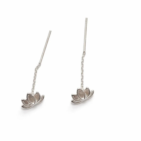 Boucles d'oreilles pendantes argentées en forme de fleur de lotus sur fond blanc